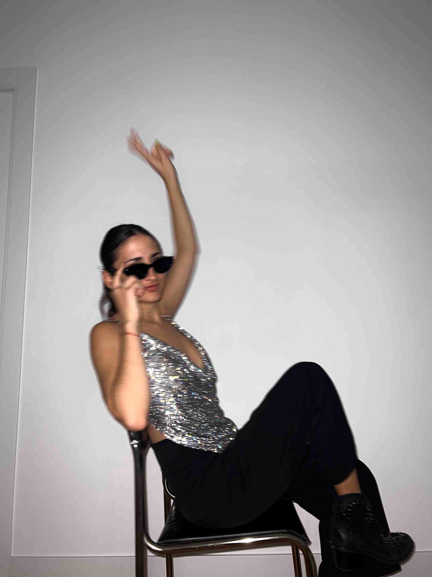 Model wears a chainmail crystal crop top in black and silver. Embellished cowl neckline top for party clothing and rave festival outfits.